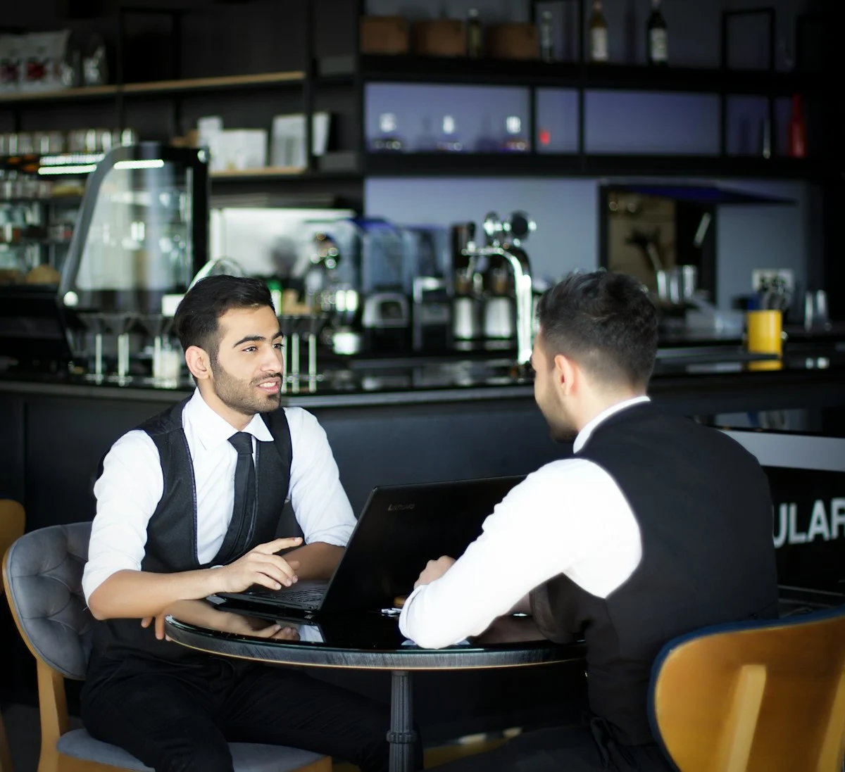 Two colleagues discussing HR strategy over a laptop
