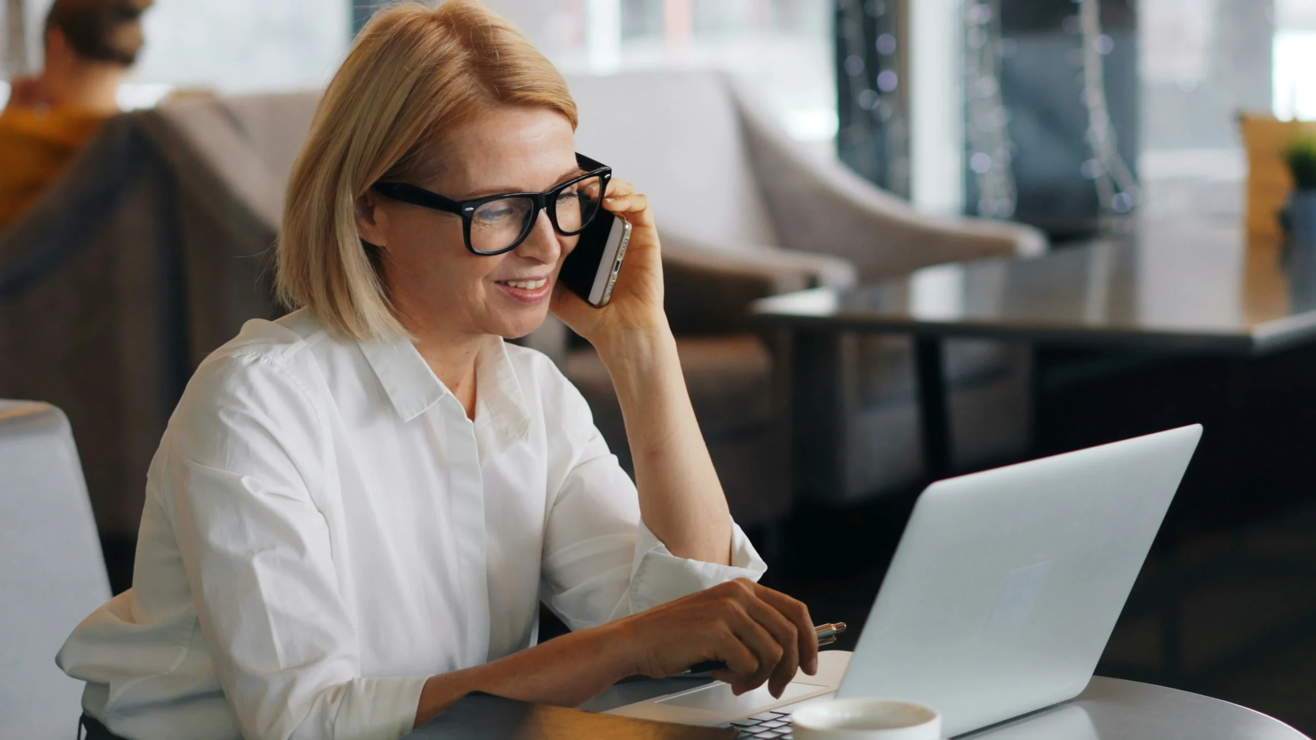 Support specialist speaking on the phone while using a laptop